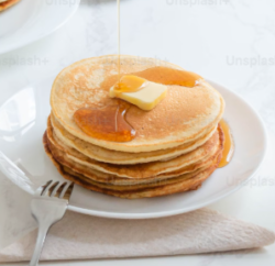 "Fluffy, healthy pancakes stacked on a plate with fresh berries and honey drizzle — a quick and nutritious breakfast option."