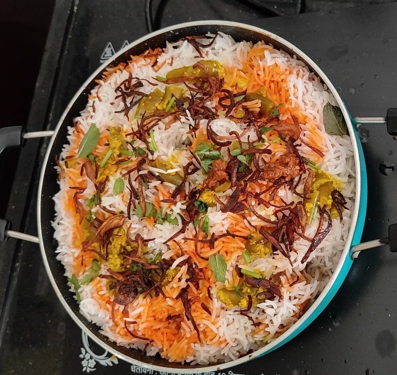 Delicious homemade chicken biryani with fragrant basmati rice, tender chicken, and fresh herbs, served in a rustic bowl